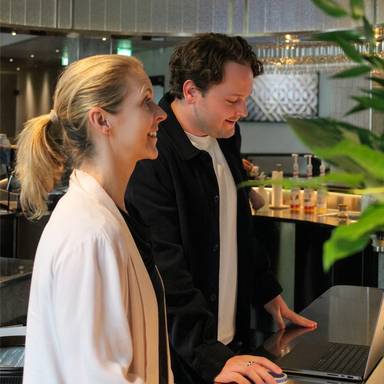 Two colleagues standing behind the espresso bar.