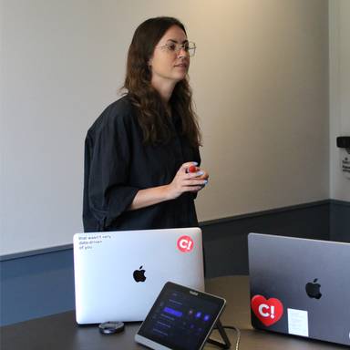 Woman in a meeting room explaining something to a colleague.